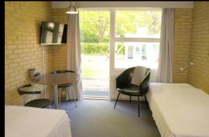 um quarto com uma cama, uma mesa e uma janela em Danhostel Horsens em Horsens