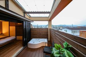 a balcony with a bath tub on a wooden deck at ROMANSTAY in Takayama