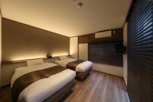 een hotelkamer met twee bedden en een raam bij ROMANSTAY in Takayama +48 foto's