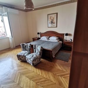 a bedroom with a bed and two chairs in it at APARTMAN FLAVIA in Rijeka
