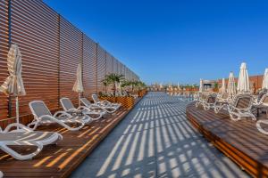 a row of chairs and umbrellas on a patio at Bera Alanya Hotel - Halal All Inclusive in Konaklı