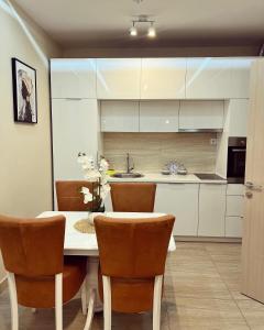 een keuken met witte kasten en een tafel en stoelen bij Nevenka in Bar