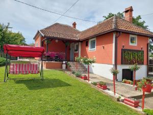 a house with a red chair in the yard at BANJANSKI RAJ in Arandjelovac