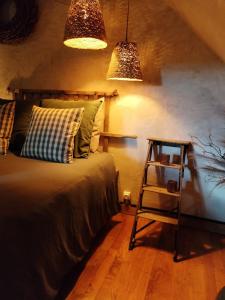 a bedroom with a bed with two lights and a ladder at La lande sèche in Lainsecq