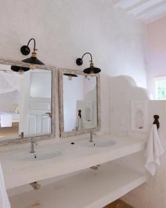 La salle de bains est pourvue de 2 lavabos et de 2 miroirs. dans l'établissement Shela Bahari, à Shela