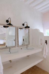 een badkamer met 2 wastafels en 2 spiegels bij Shela Bahari in Shela