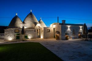 um edifício de pedra com luzes acesas à noite em Bed and Breakfast Trulli San Leonardo em Alberobello