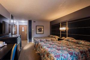 a hotel room with two beds and a desk at Coratel Inn & Suites by Jasper Hastings in Hastings