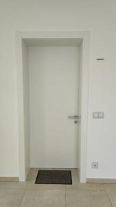 een witte kamer met 2 deuren en een tapijt bij Skiper Apartments & Golf Resort in Savudrija