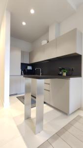 a kitchen with white cabinets and a black counter top at Skiper Apartments & Golf Resort in Savudrija