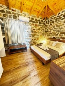 a bedroom with a bed and a brick wall at Lithos Apartments in Evdilos
