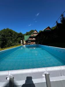 a large swimming pool with a building in the background at Pienińska Willa Aleksandrówka in Szczawnica