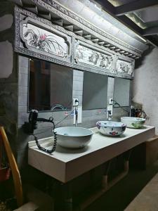a counter with two bowls on top of a sink at Lijiang Adventure Inn in Lijiang