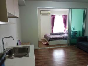 a kitchen and living room with a couch and a window at Mari Space in Nonthaburi +5 photos