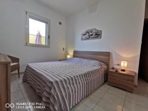 une chambre avec un grand lit et une fenêtre dans l'établissement VILLETTA A SCHIERA DUE vicino MALDIVE DEL SALENTO, à Torre Pali