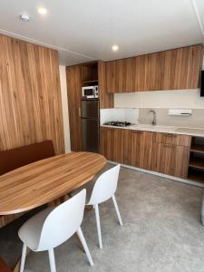 uma cozinha com uma mesa de madeira e cadeiras brancas em Best Holiday Port Grimaud em Grimaud