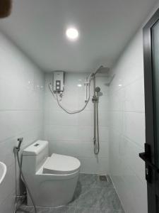 bagno bianco con servizi igienici e doccia di Cozy Duplex Apartment near Bui Vien, Ben Thanh Market ad Ho Chi Minh