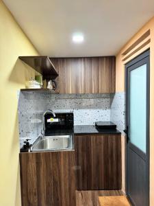 una cucina con armadi in legno e lavandino di Cozy Duplex Apartment near Bui Vien, Ben Thanh Market ad Ho Chi Minh