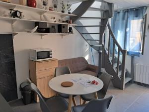 una pequeña sala de estar con mesa y sillas. en Charmante Maison à 15 minutes de la place Comédie en Montpellier