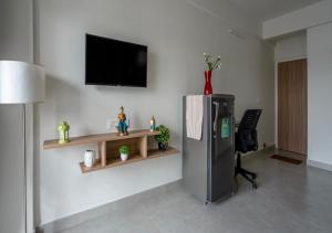 Habitación con nevera y TV en la pared. en Wandr Centauri - Whitefield , Bangalore en Bangalore