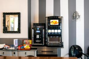 Hotel Volta في بادوفا: آلة القهوة موجودة على منضدة بجوار مرآة