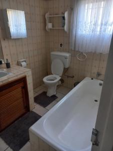 a bathroom with a tub and a toilet and a sink at Wildepeer in Nelspruit