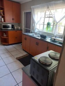 a kitchen with a sink and a microwave at Wildepeer in Nelspruit