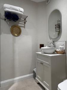 Baño blanco con lavabo y espejo en The Old Rectory Tack Rooms, en Shrewsbury
