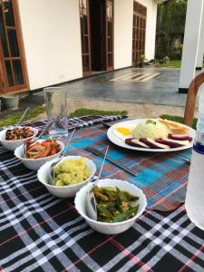a picnic table with plates of food on it at Lucky's Homestay in Maho