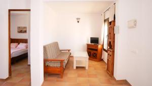 a bedroom with a bed and a chair and a desk at Apartamentos Hacienda Sajorami in Zahora