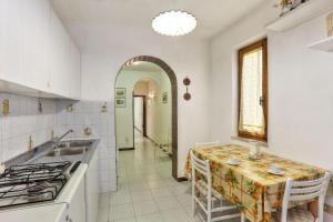 a kitchen with a table and a sink and a stove at Casa Helba - Colle Paradiso Experience in Capoliveri