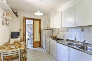 a kitchen with a sink and a refrigerator at Casa Helba - Colle Paradiso Experience in Capoliveri