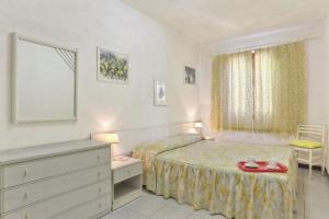 a small bedroom with a bed and a dresser at Casa Helba - Colle Paradiso Experience in Capoliveri