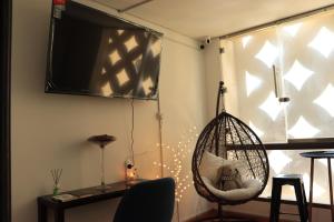 ドバイにあるLa vie en roseのハンギングチェアと窓が備わる客室です。