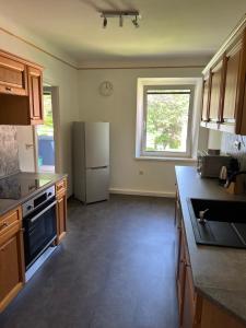 a large kitchen with a refrigerator and a window at Eisenerz Alpine Apartement RoSy in Eisenerz