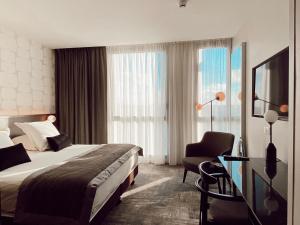 una camera d'albergo con letto e sedia di Hotel du Pasino a Saint-Amand-les-Eaux