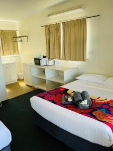 Habitación de hotel con 2 camas y microondas en Clermont Hotel Motel en Clermont