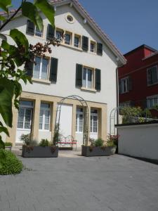 Biały dom z dziedzińcem przed nim w obiekcie Guest house - Maison d'hôtes "Relais des Saars" w mieście Neuchâtel
