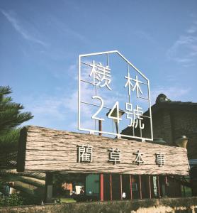 un panneau au-dessus d'un bâtiment avec des écrits asiatiques dans l'établissement Sigang Grandma House, à Xigang
