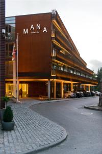 een groot gebouw met auto's geparkeerd voor het bij Mana Suites & Sea in Palanga
