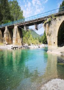 un puente con un tren sobre un río en Alojamiento Tierra del Ara, en Boltaña