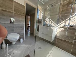 ペロルにあるNouveau Appartement PEROLS rénové en 2024のトイレとガラスのシャワー付きのバスルーム