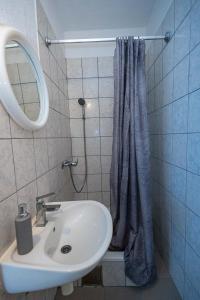 a bathroom with a sink and a shower curtain at Studio apartment Kasalo in Kaštela