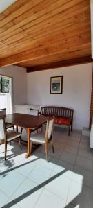 a dining room with a table and chairs and a bench at Chez Jeannot et Jeannette in Allards
