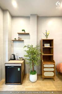 un salon avec une télévision et une plante dans l'établissement FSTAY GARDEN CORNER - Cozy and Peaceful Homestay in Da Nang, à Đà Nẵng