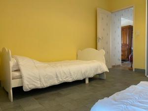 a bedroom with a bed and a yellow wall at Chez Jeannot et Jeannette in Allards