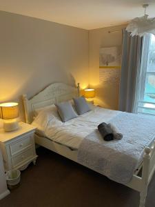 a bedroom with a white bed with two lamps on it at Market Hill Apartments in Royston