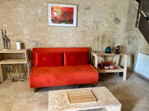 sala de estar con sofá rojo y mesa en Borderie de Vérone, en Espiens