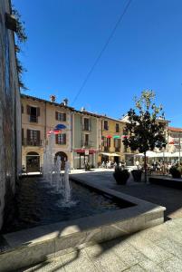 una fontana in mezzo a una strada con edifici di Bilocale Vecchio Borgo a Borgosesia