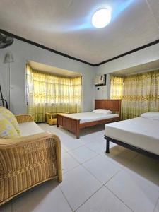a large room with two beds and a couch at Bohol Sea Breeze Cottages and Resort in Panglao